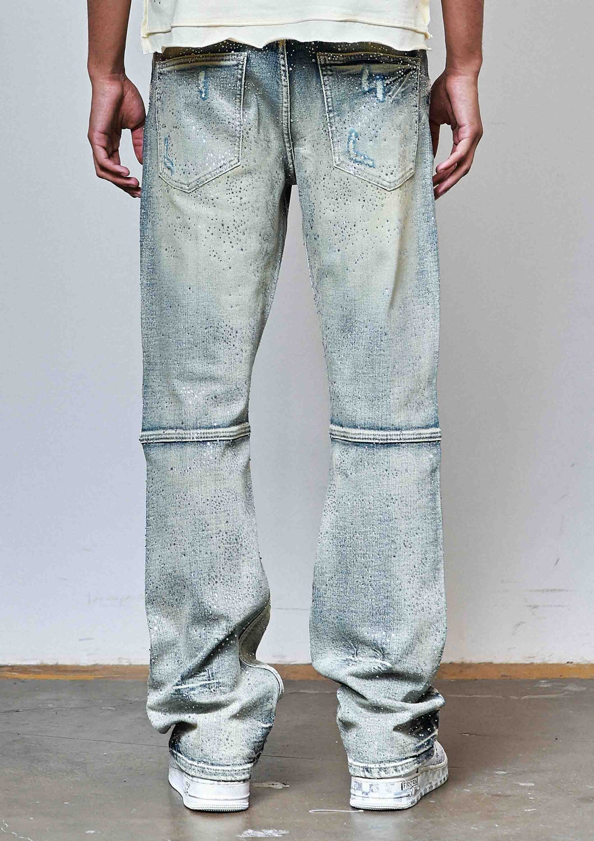 Men's medium stone flare jeans with allover rhinestones and rip and repair