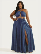 Woman wearing a blue denim dress with cut-out design on a white background