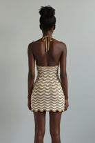 Woven dress on a mannequin against a beige background