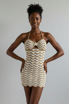 Beige and white crochet dress on a mannequin against a beige background