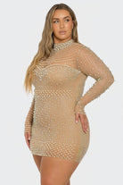A woman modeling a sheer beige long-sleeve mini dress covered in rows of small pearl-like beads against a light gray studio background.
