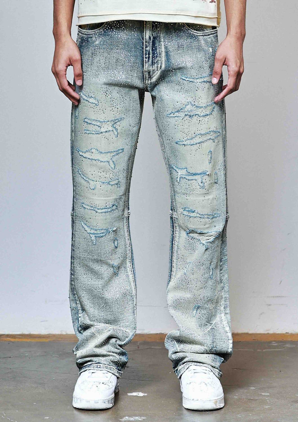 Men's medium stone flare jeans with allover rhinestones and rip and repair