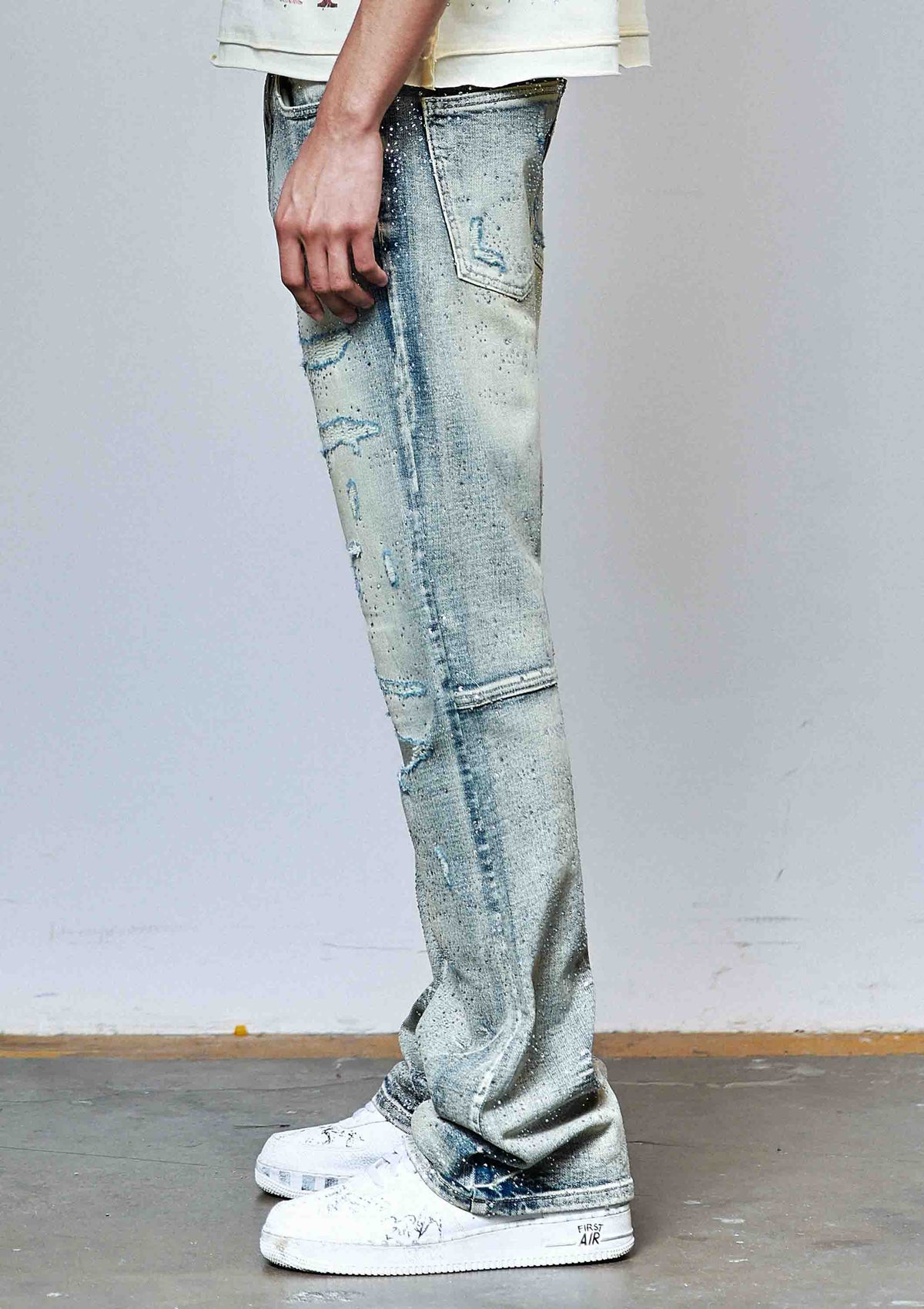 Men's medium stone flare jeans with allover rhinestones and rip and repair